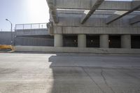 the sun is shining on some concrete buildings as seen from the street below the ramp