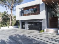 the exterior and landscape of a modern house in los angeles, california with stone and wood