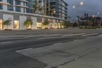 two street lights next to a store front and a very tall building in the background