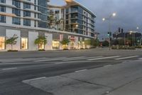 two street lights next to a store front and a very tall building in the background