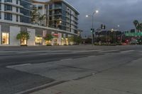 two street lights next to a store front and a very tall building in the background