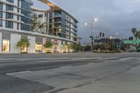 two street lights next to a store front and a very tall building in the background