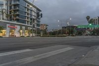 two street lights next to a store front and a very tall building in the background