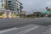 two street lights next to a store front and a very tall building in the background