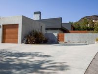 a gray concrete building with stairs and door at the top of the floor next to it is steps leading down to the doorway