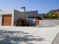 a gray concrete building with stairs and door at the top of the floor next to it is steps leading down to the doorway