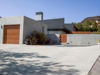 a gray concrete building with stairs and door at the top of the floor next to it is steps leading down to the doorway