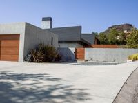 a gray concrete building with stairs and door at the top of the floor next to it is steps leading down to the doorway