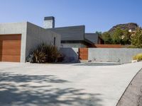 a gray concrete building with stairs and door at the top of the floor next to it is steps leading down to the doorway