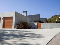 a gray concrete building with stairs and door at the top of the floor next to it is steps leading down to the doorway