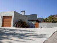 a gray concrete building with stairs and door at the top of the floor next to it is steps leading down to the doorway