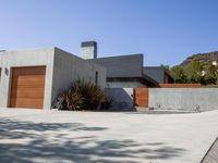 a gray concrete building with stairs and door at the top of the floor next to it is steps leading down to the doorway