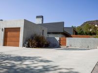 a gray concrete building with stairs and door at the top of the floor next to it is steps leading down to the doorway