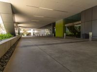 the walkway leading to a modern office building with several planters next to it and a skylight