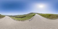 the panorama lens makes a 360 - view of a motorcycle rider riding along the road