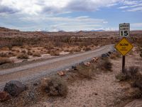 a sign in the middle of a desert road with an empty road below it, and another road below it