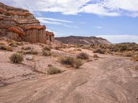 the dirt is brown and empty, as the grass stands out against the rock formations