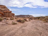 the dirt is brown and empty, as the grass stands out against the rock formations