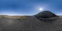 the sun is shining on a mountain and its shadow is visible behind it as if in the panorama fisheye lens