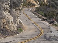 the motorcycle is moving through a curve on a mountain road along with trees in the foreground