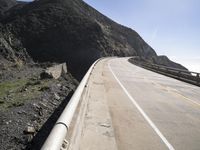 a long highway with two lanes and traffic lines on either side and in the distance are a high mountain