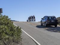 there are some people in the car watching bikes take off from the road in front