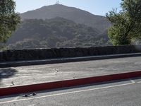 a person skateboards down the street with a mountain in the background at dawn and late afternoon