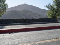 a person skateboards down the street with a mountain in the background at dawn and late afternoon