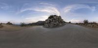 a 360 - view photograph of a long road going through the mountains in the sunset