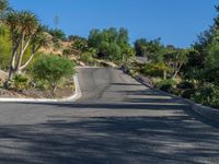 a woman is riding her motorcycle down a curved mountain road as she approaches the camera