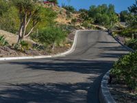 a woman is riding her motorcycle down a curved mountain road as she approaches the camera