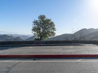 an empty parking lot with mountains in the distance at sunrise hours on a sunny day