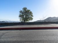 an empty parking lot with mountains in the distance at sunrise hours on a sunny day