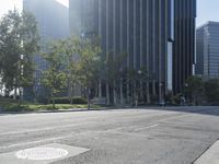 a person walking down a deserted city street with skyscrapers in the background in the daytime