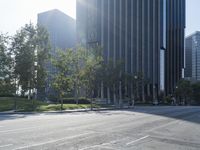 a person walking down a deserted city street with skyscrapers in the background in the daytime