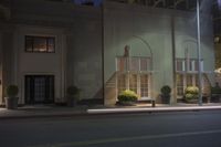 a building that has two buildings on the front with stairs in front at night light