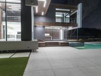 a large, modern home is in the dark, with concrete floors and white walls