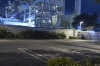 an industrial power plant with lights lit on the side of it at night time - the sky is clear