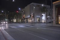 a picture of some very nice looking buildings and street lights at night time while a car is passing by