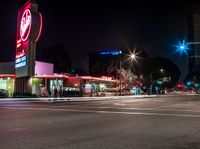 an empty street with signs on the front and back of it at night near some buildings