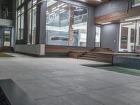 a gray and grey outdoor area next to the pool with benches and steps that leads into another room