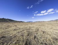 the vast dry prairie sits empty in a sunny day with a few clouds in the sky