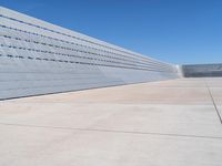 the sidewalk is lined up with concrete blocks and a blue sky above it on a sunny day