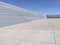 the sidewalk is lined up with concrete blocks and a blue sky above it on a sunny day