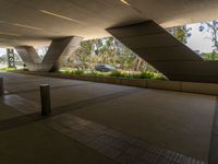 a building with a ramp leading to trees and plants in the front and rear of it