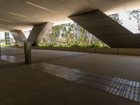 a building with a ramp leading to trees and plants in the front and rear of it