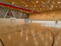 a wooden court with black and red lines and basketball hoops on the bottom of it