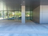 two grey blocks sitting next to a tall building on a sidewalk in front of grass