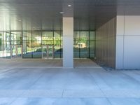 two grey blocks sitting next to a tall building on a sidewalk in front of grass