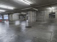 empty parking garage with lots of empty concrete walls and large cement floors, with lots of empty spaces on the left